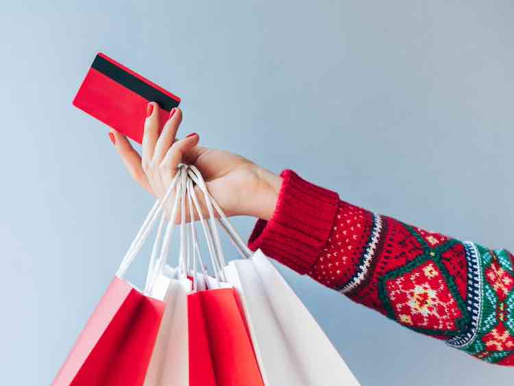 woman hand holding many paper handbags and red credit card.